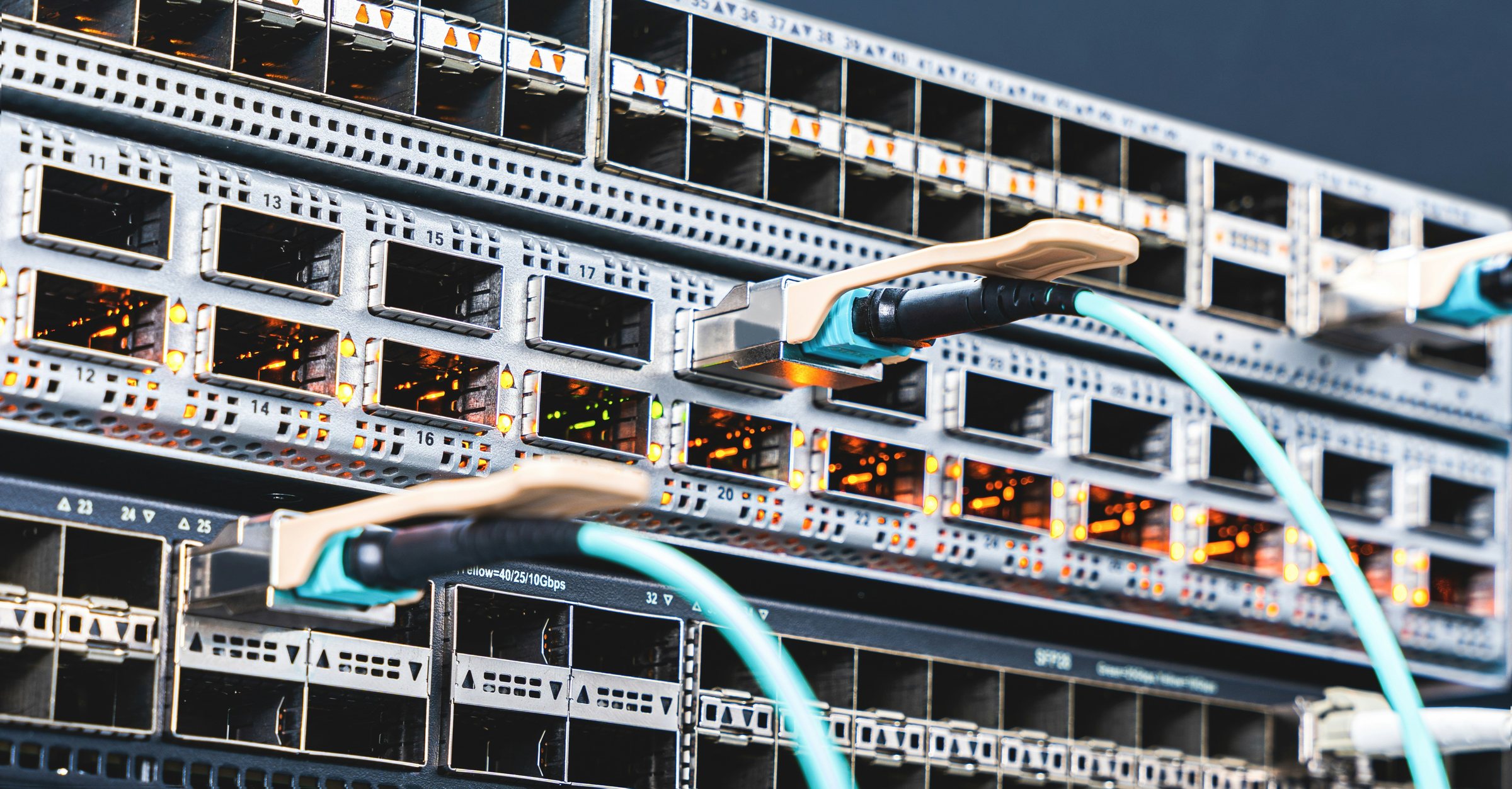 Cabos de rede conectados a um switch em um rack.